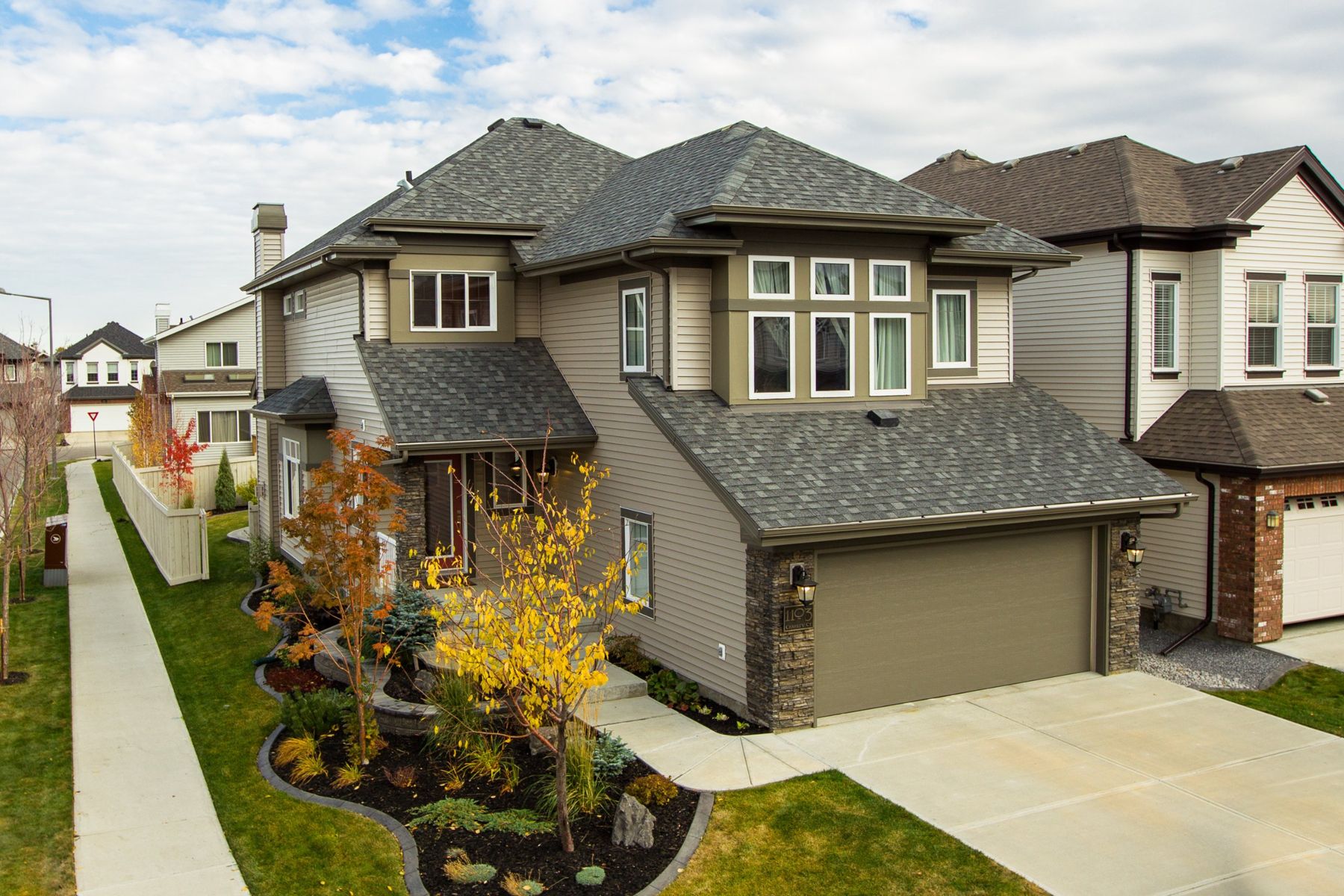 A two-storey home with stone accents and fall colours