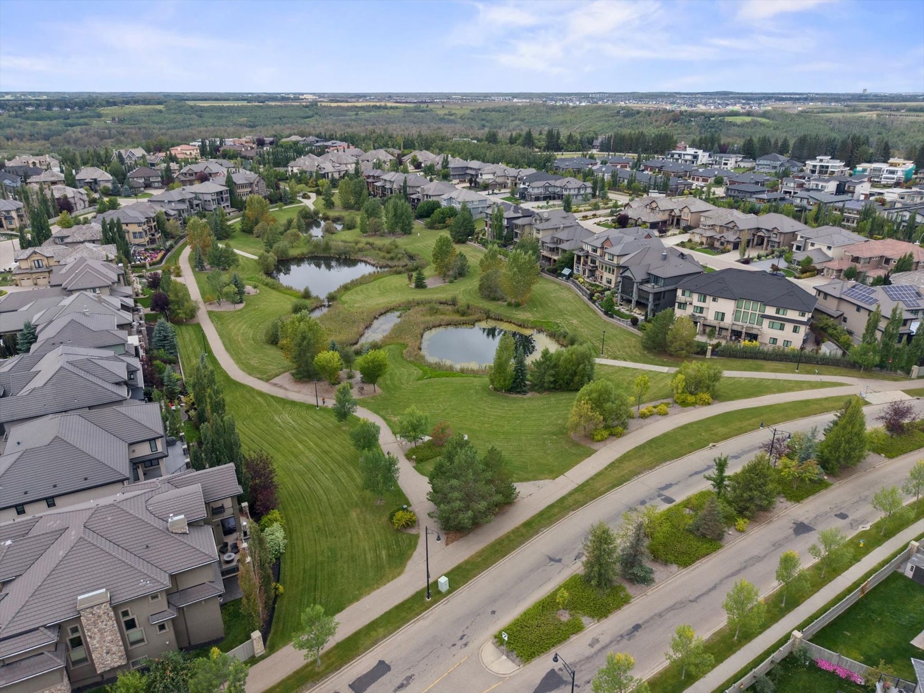 Aerial view of a river valley neighbourhood with ponds and walking paths
