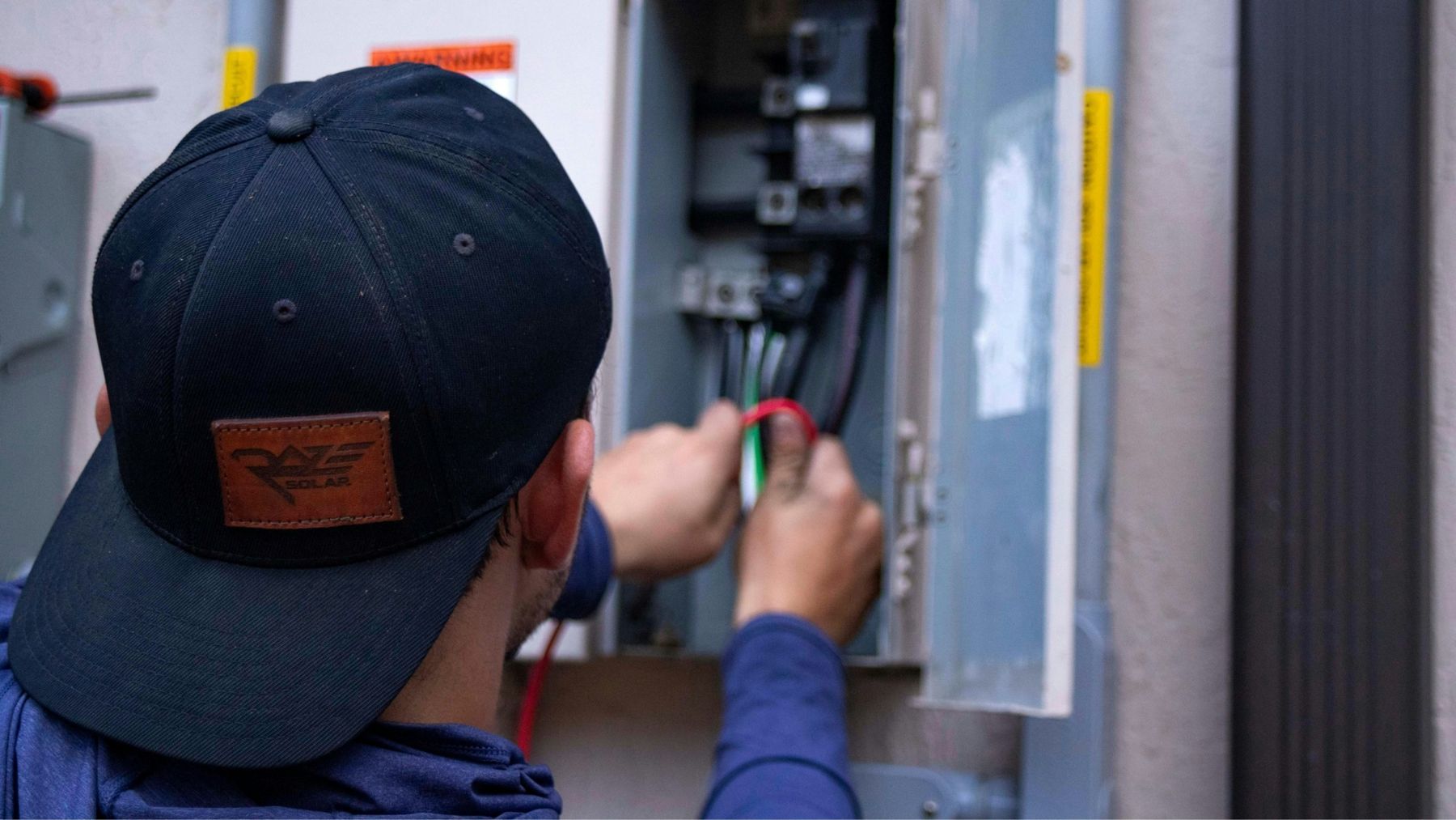 An electrician wiring a home electrical panel