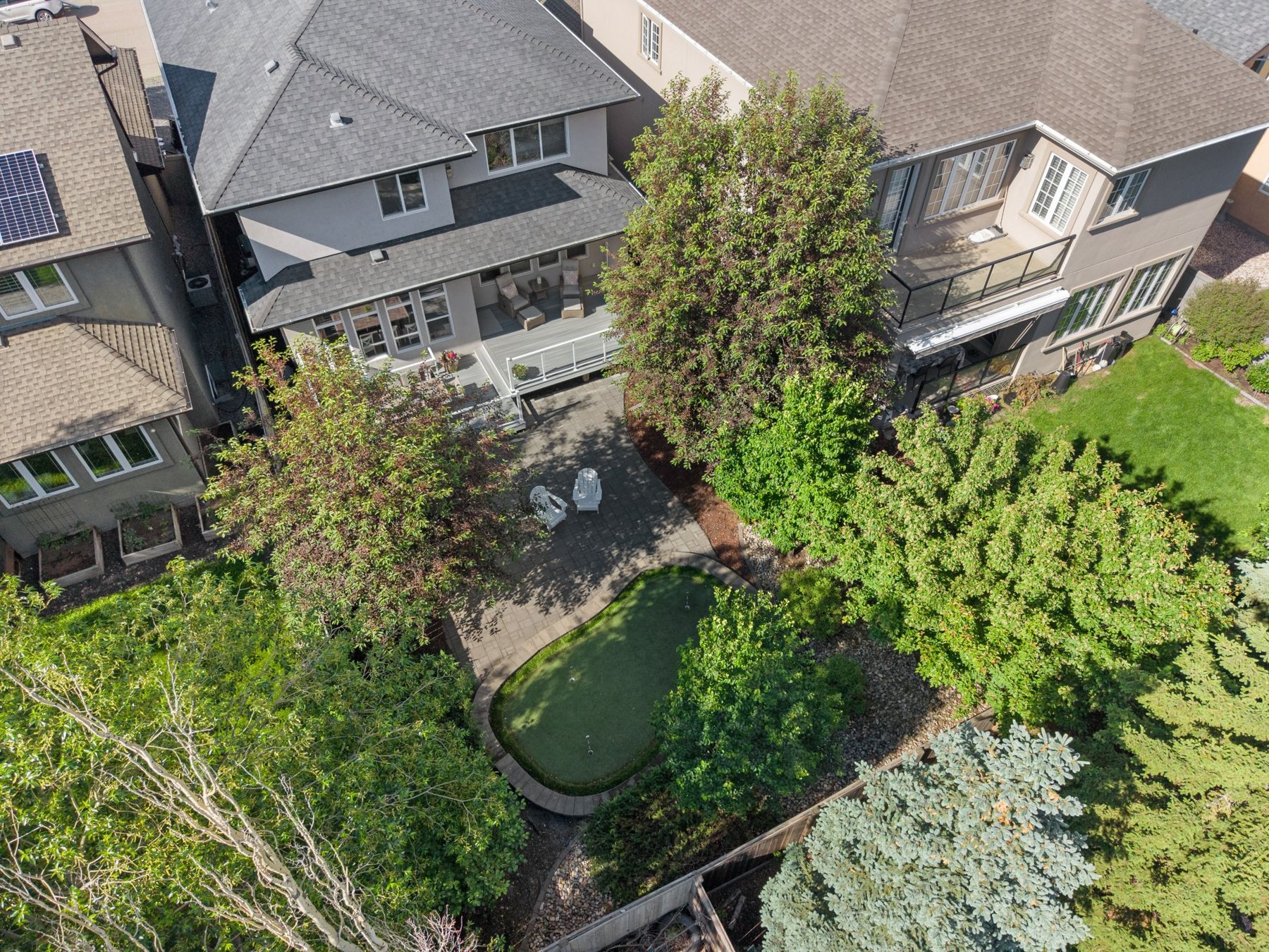 Aerial view of a backyard with a putting green and patio