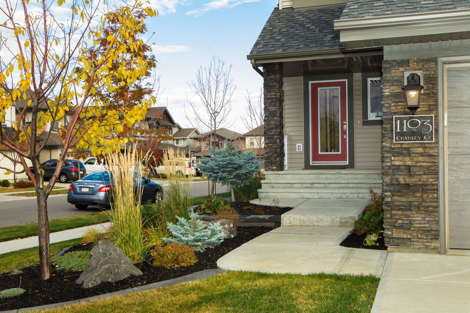 Front entry with a red door and landscaped garden