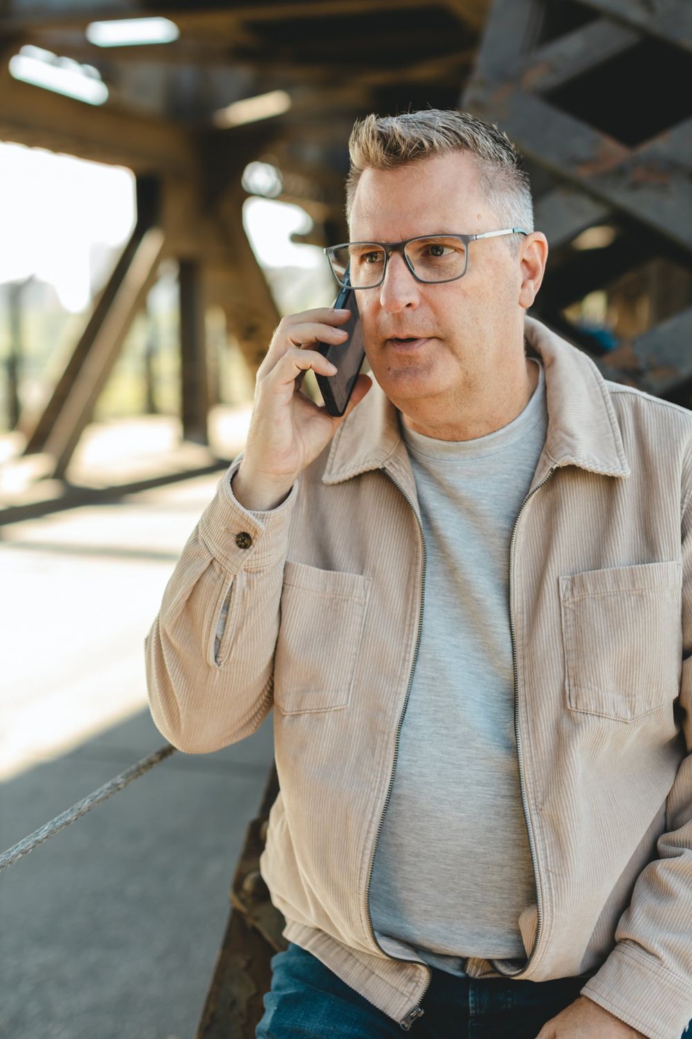 Brad Richardson taking a call under a steel bridge